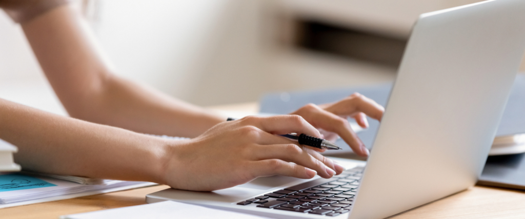 Hands typing on laptop